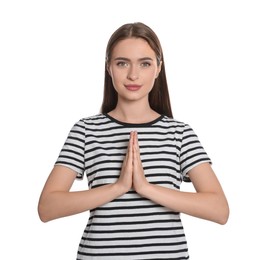 Woman with clasped hands praying on white background