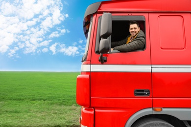 Portrait of happy driver in cab of modern truck