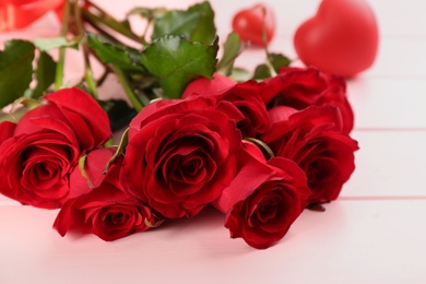 Beautiful red roses on pink table, closeup. Valentine's Day celebration