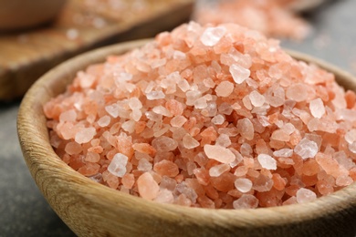 Pink himalayan salt in wooden bowl on table, closeup