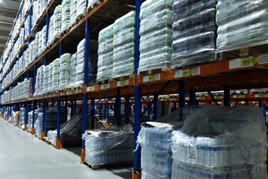Photo of Warehouse interior with metal racks full of merchandise. Wholesale business