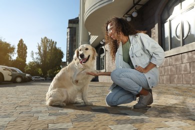 Young African-American woman and her Golden Retriever dog outdoors