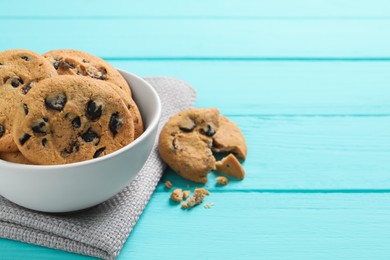 Bowl with many delicious chocolate chip cookies on turquoise wooden table. Space for text