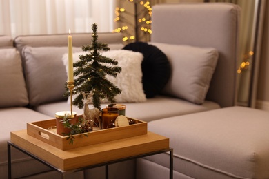 Composition with decorative Christmas tree and reindeer on wooden tray in living room