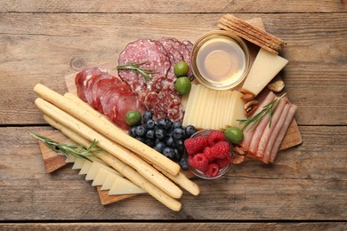 Snack set with delicious Parmesan cheese on wooden table, top view
