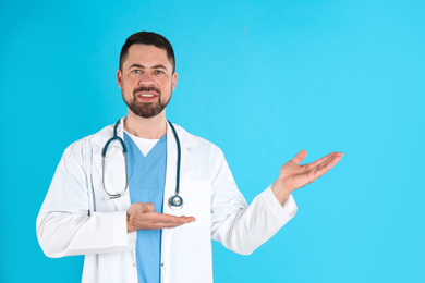 Photo of Mature doctor with stethoscope on blue background
