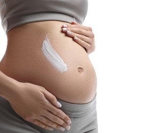 Pregnant woman applying cosmetic product on belly against white background, closeup
