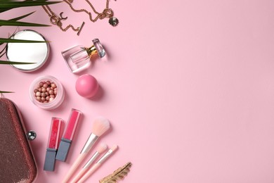 Flat lay composition with makeup products on pink background, space for text