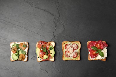 Photo of Tasty toasts with different toppings on black table, flat lay. Space for text