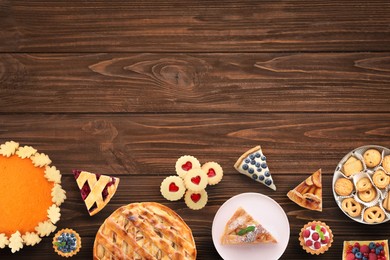 Flat lay composition with different delicious pies on wooden table. Space for text