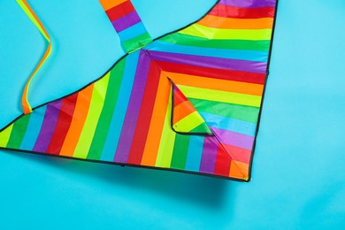 Bright rainbow kite on light blue background, top view