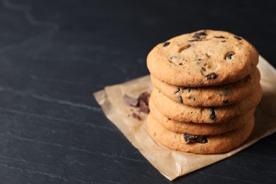 Delicious chocolate chip cookies on black table. Space for text