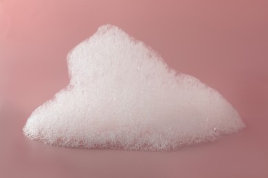 Fluffy bath foam on pink background, closeup