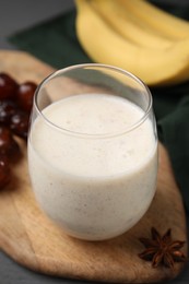 Photo of Glass of delicious date smoothie on wooden board, closeup