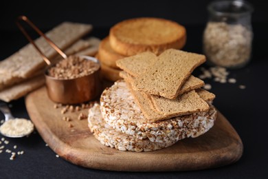 Rye crispbreads, rice cakes and rusks on black table