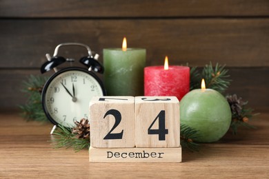 Photo of December 24 - Christmas Eve. Wooden block calendar and festive decor on table