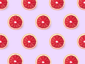 Slices of red oranges on pink background, flat lay 