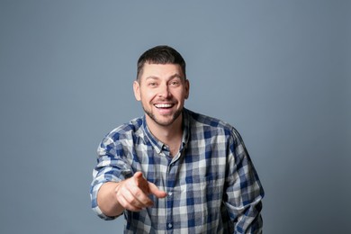 Handsome man laughing on grey background. Funny joke