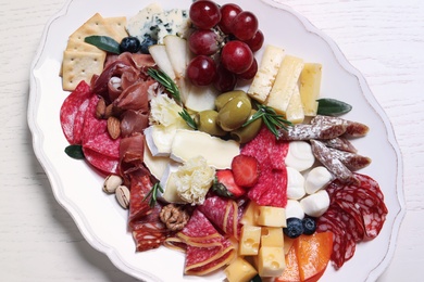 Photo of Assorted appetizers served on white wooden table, top view