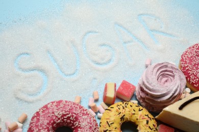 Photo of Composition with sweets and word SUGAR on light blue background