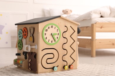 Busy board house on floor indoors. Baby sensory toy