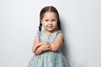Cute little girl on light grey background