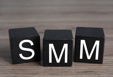 Cubes with abbreviation SMM (Social media marketing) on wooden table