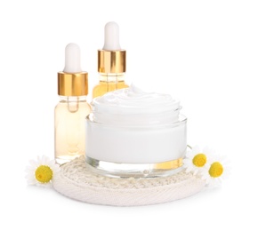 Chamomile flowers and cosmetic products on white background