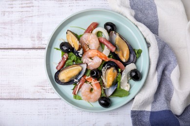 Photo of Plate of delicious salad with seafood on white wooden table, flat lay