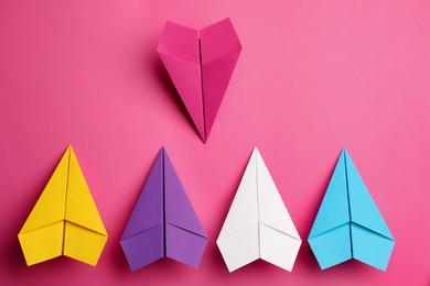Photo of Flat lay composition with colorful paper planes on pink background