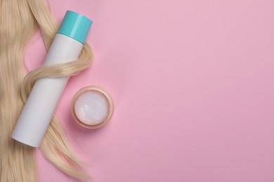 Lock of healthy blond hair and cosmetic products on pink background, flat lay. Space for text