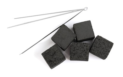 Charcoal cubes for hookah and tongs on white background, top view