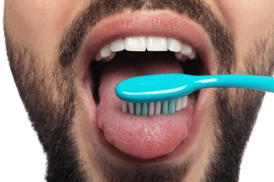 Man brushing his tongue on white background, closeup. Dental care