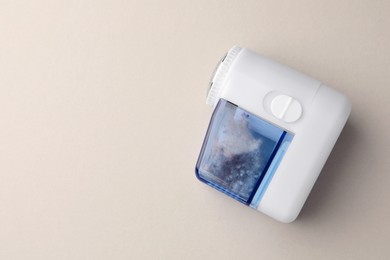 Photo of Modern fabric shaver with fuzz on white background, top view. Space for text