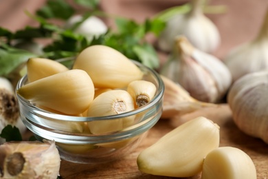 Fresh peeled garlic cloves in bowl on table, closeup. Organic product