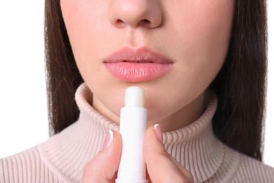 Young woman applying cold sore balm on lips, closeup