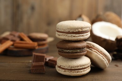 Photo of Delicious macarons and chocolate on wooden table