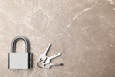 Steel padlock, keys and space for text on marble background, flat lay. Safety concept