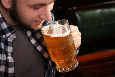 Man drinking tasty beer in pub, closeup. Space for text