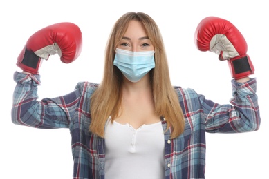 Woman with protective mask and boxing gloves on white background. Strong immunity concept