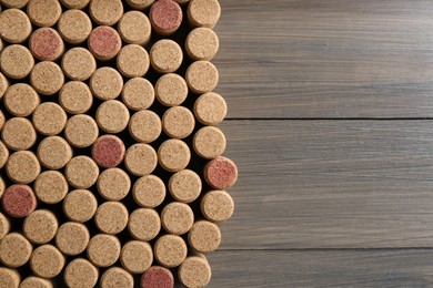 Flat lay composition with many corks of wine bottles on wooden table. Space for text