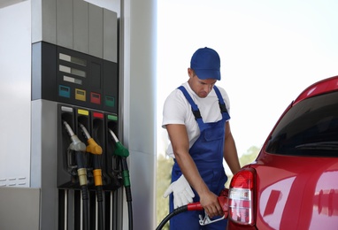 Photo of Worker refueling car at modern gas station