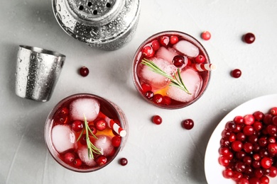 Tasty refreshing cranberry cocktail on light grey table, flat lay