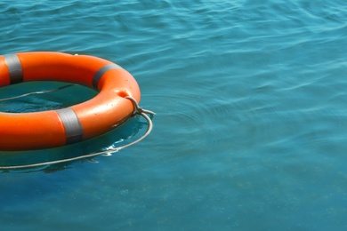 Orange life buoy floating in sea. Emergency rescue equipment