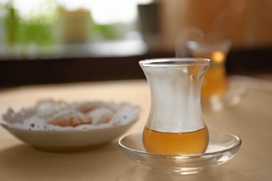 Glass cup of aromatic tea on table