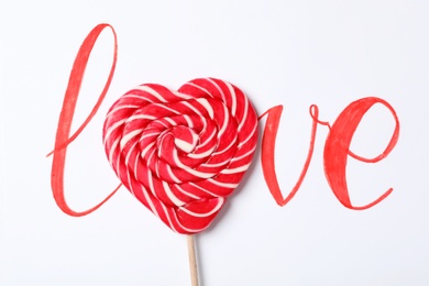 Word Love with heart shaped lollipop on white background, top view. Valentine's day celebration