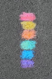 Rainbow chalk strokes on asphalt, top view