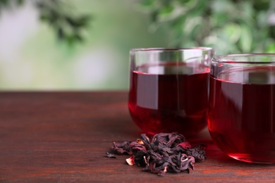 Freshly brewed hibiscus tea on wooden table, closeup. Space for text