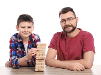 Little boy and his dad playing board game on white background