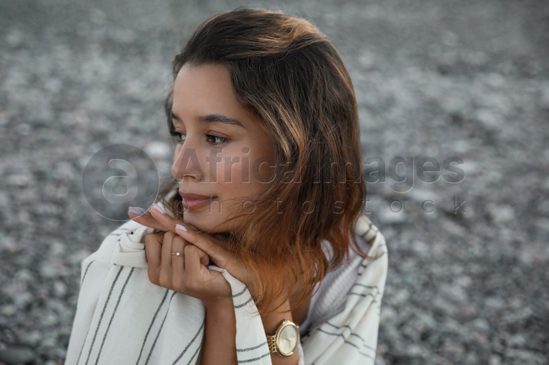 Portrait of beautiful young woman on pebble beach